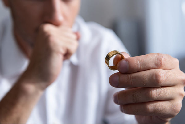 partial view of man holding ring at home